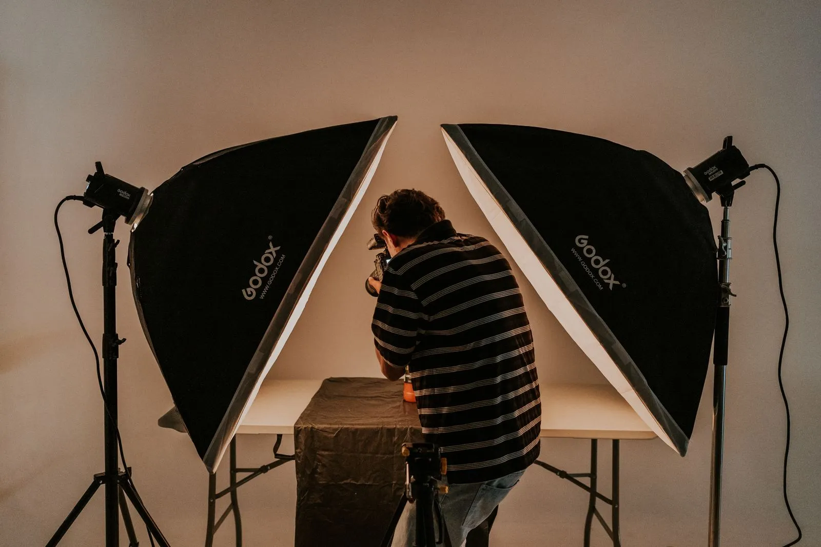 Softbox aydınlatmasıyla stüdyoda ürün çekimi yapan fotoğrafçı